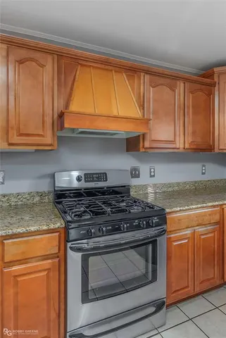 a kitchen with granite countertop wooden cabinets stainless steel appliances and a sink