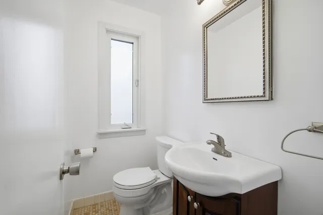 a bathroom with a toilet sink and mirror