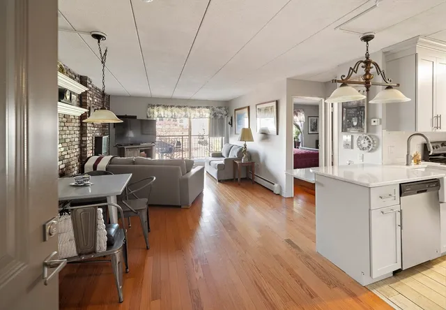 a view of living room and kitchen with wooden floor