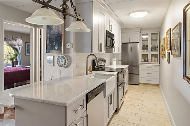 a kitchen with stainless steel appliances granite countertop a sink and a refrigerator