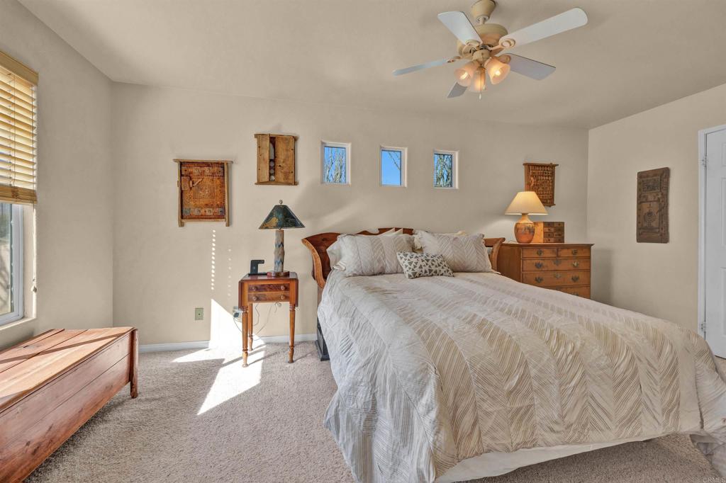 3486 Swinging V Road Borrego Springs, CA 92004 - Photo 18 of 41 a spacious bedroom with a bed and a chandelier