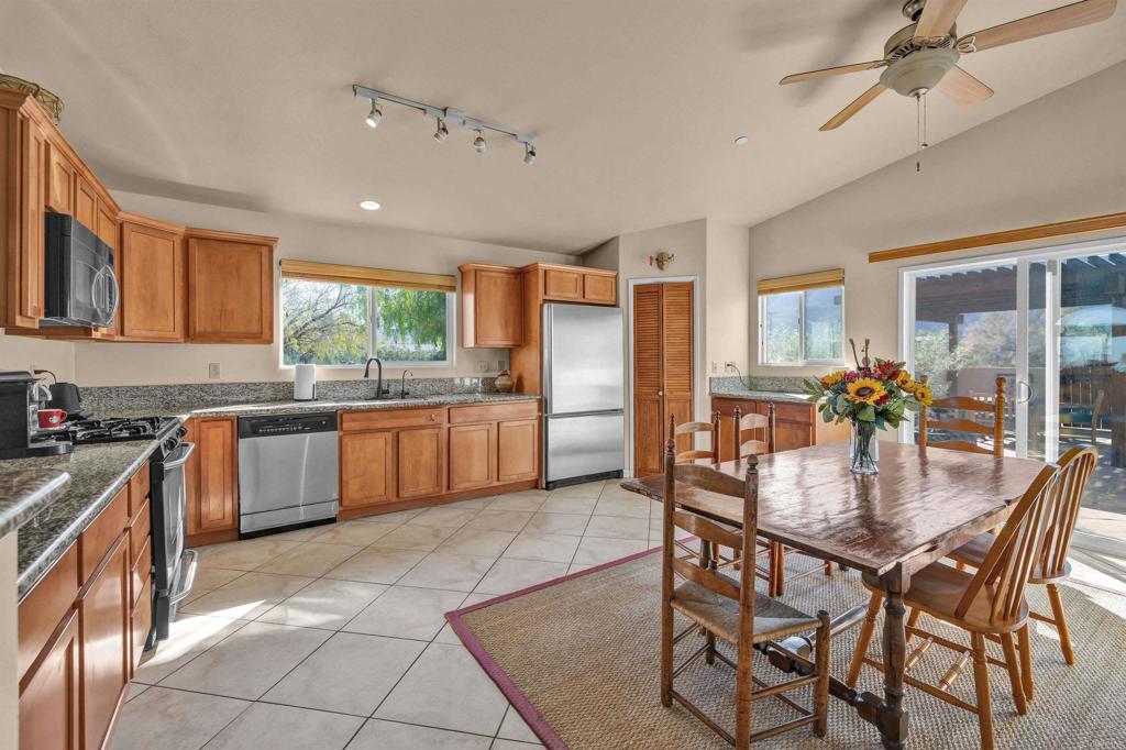 3486 Swinging V Road Borrego Springs, CA 92004 - Photo 2 of 41 a kitchen with stainless steel appliances granite countertop a stove top oven a sink dishwasher a dining table and chairs with wooden floor