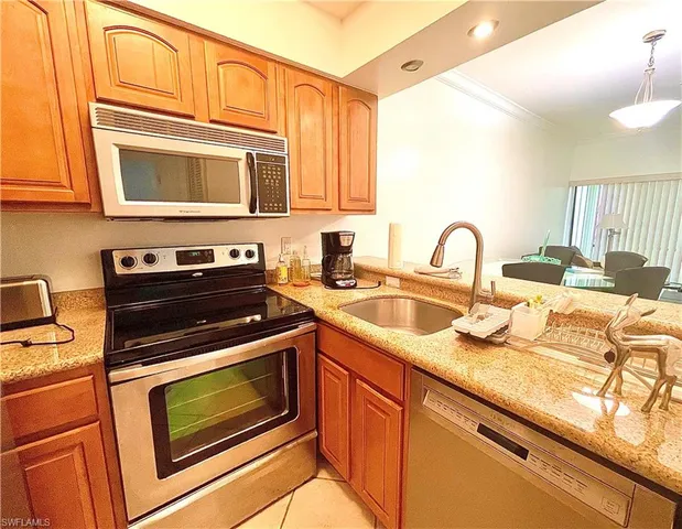 a kitchen with stainless steel appliances granite countertop a stove a sink and a microwave