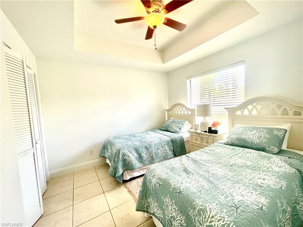 Undisclosed Address Naples, FL 34105 - Photo 6 of 15 a bedroom with two beds and a chandelier