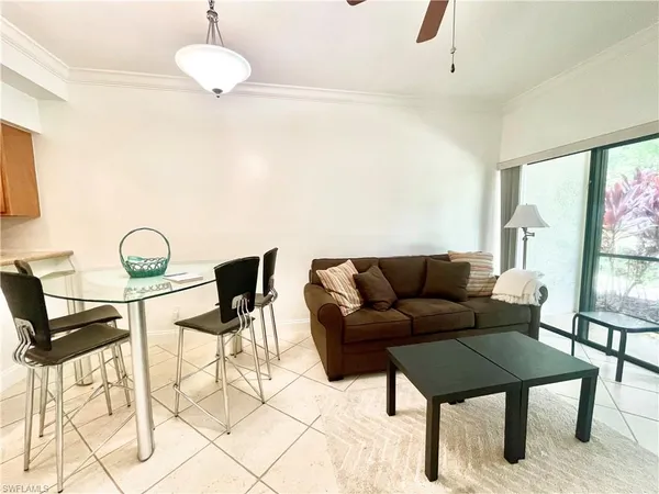 a living room with furniture a flat screen tv and a large window