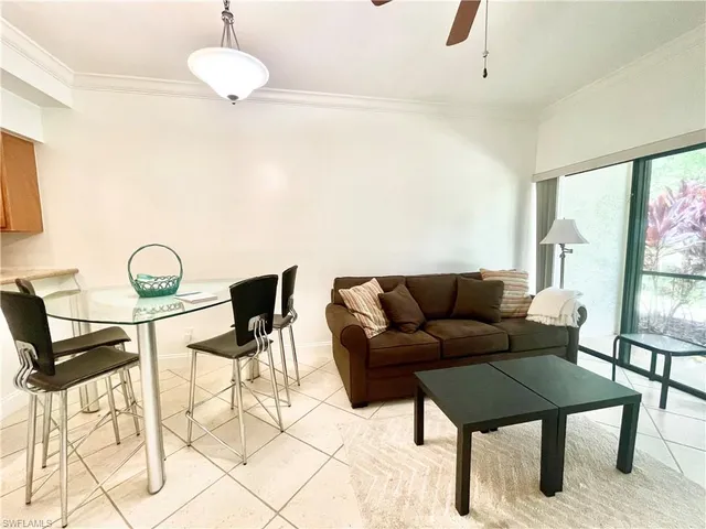 a living room with furniture a flat screen tv and a large window