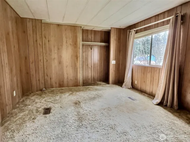 an empty room with windows and closet