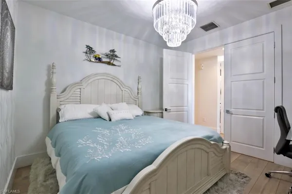 a bedroom with a bed and a chandelier
