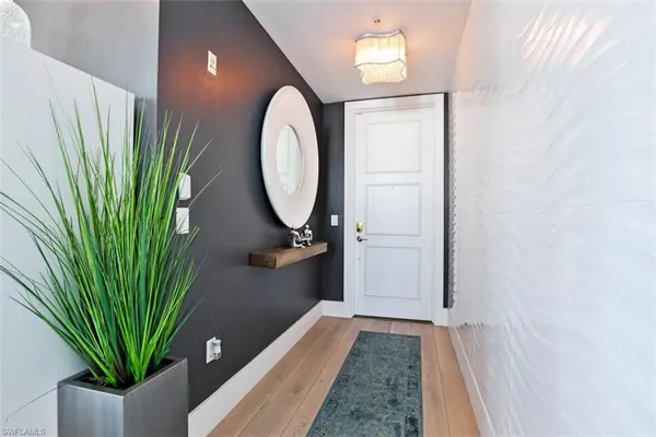 a view of a hallway with wooden floor and a plant
