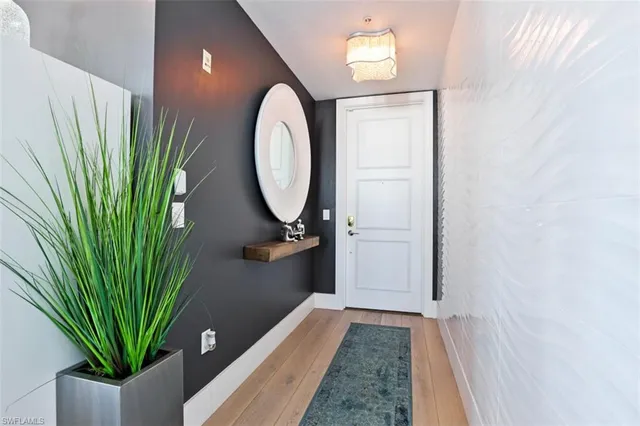 a view of a hallway with wooden floor and a plant