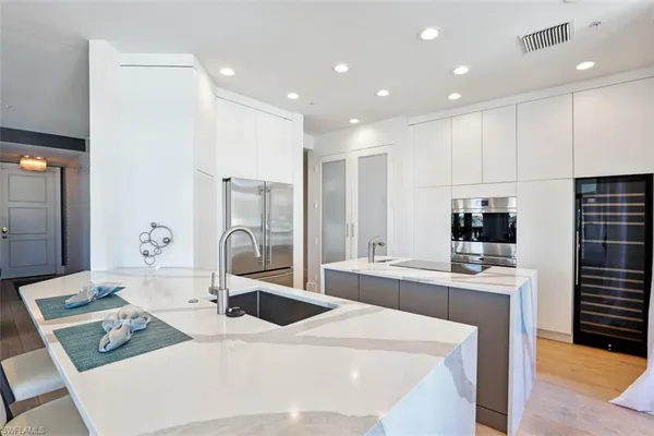 a large kitchen with kitchen island a stove a sink and a refrigerator