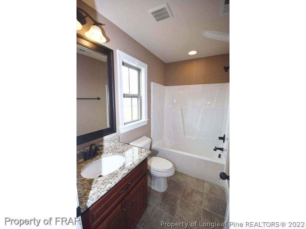 800 South River Road Stedman, NC 28391 - Photo 17 of 23 a bathroom with a granite countertop sink a toilet and shower
