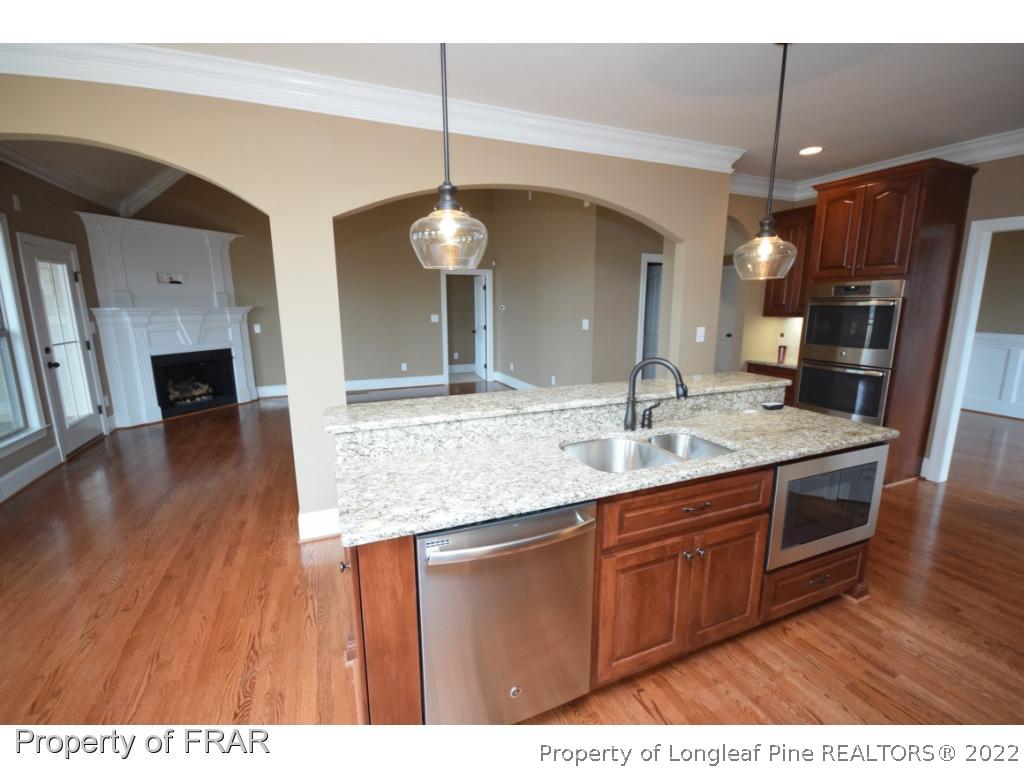 800 South River Road Stedman, NC 28391 - Photo 6 of 23 a kitchen with stainless steel appliances granite countertop a sink a stove top oven a refrigerator and wooden floor