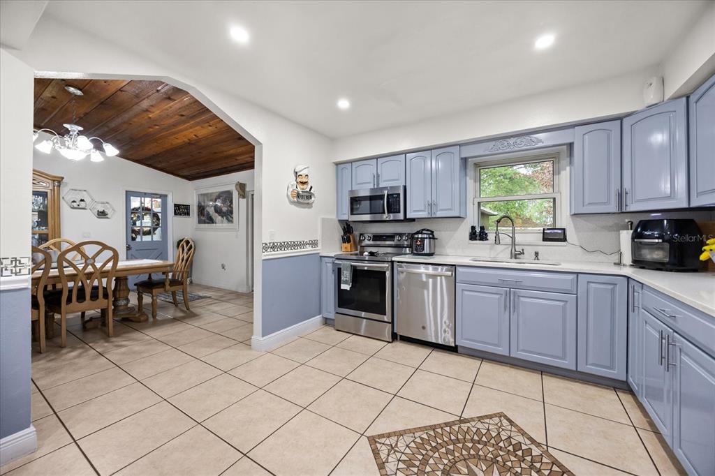 2270 Old Hickory Tree Road St. Cloud, FL 34772 - Photo 21 of 40 a kitchen with stainless steel appliances granite countertop a stove a sink a dining table and chairs