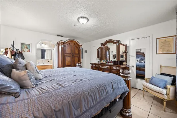 a spacious bedroom with a bed a couch and dresser