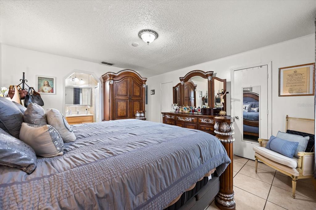 2270 Old Hickory Tree Road St. Cloud, FL 34772 - Photo 24 of 40 a spacious bedroom with a bed a couch and dresser