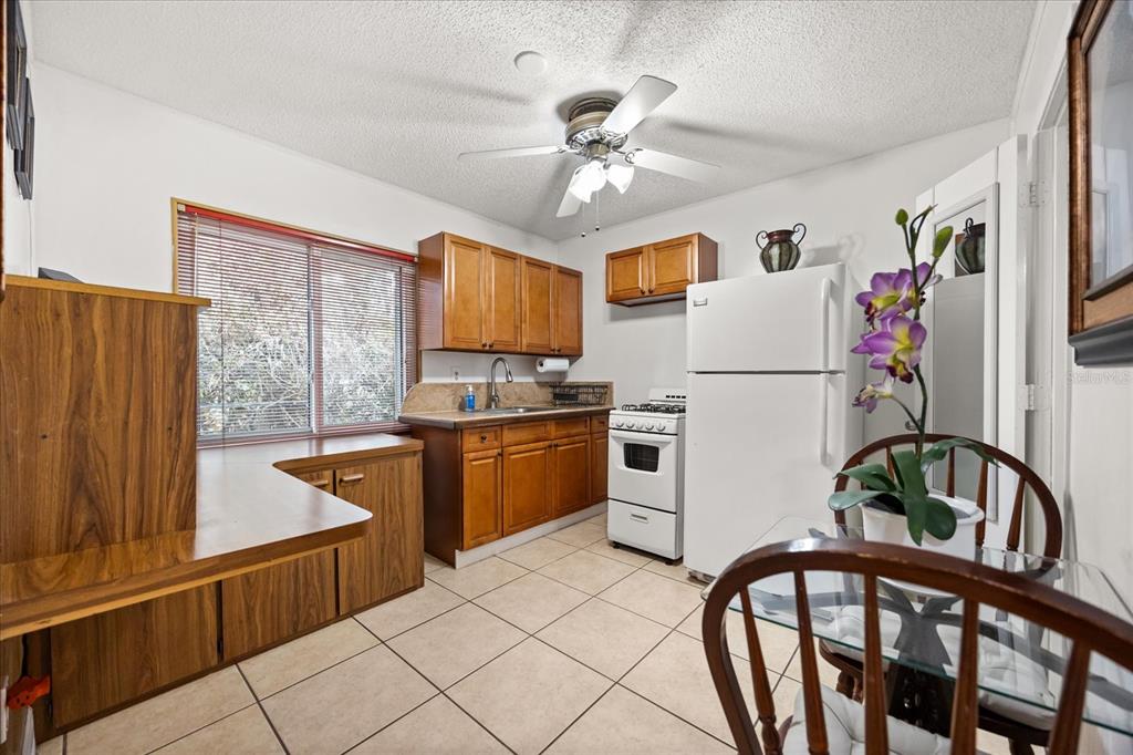 2270 Old Hickory Tree Road St. Cloud, FL 34772 - Photo 30 of 40 a kitchen with a refrigerator a stove cabinets and a dining table