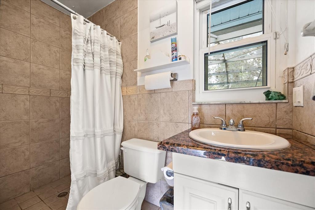 2270 Old Hickory Tree Road St. Cloud, FL 34772 - Photo 32 of 40 a bathroom with a sink a toilet a mirror and a shower