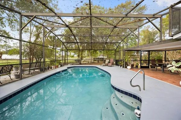 a swimming pool with outdoor seating and outdoor shower
