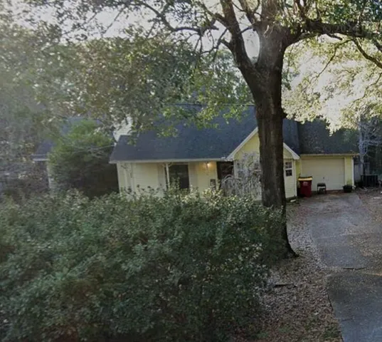 a view of a house with a tree in the background