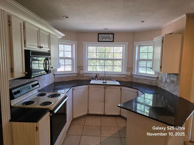 a kitchen with a stove a sink and a microwave