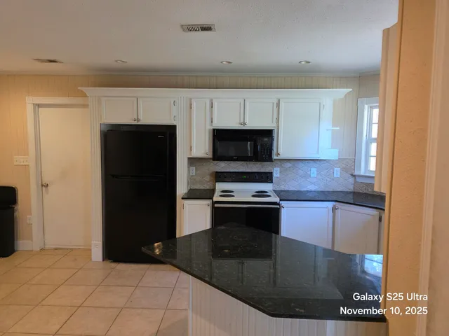 a kitchen with stainless steel appliances granite countertop a refrigerator and a stove top oven