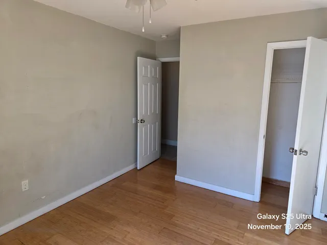 an empty room with wooden floor and entrance