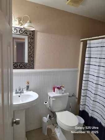 a bathroom with a toilet a sink and mirror