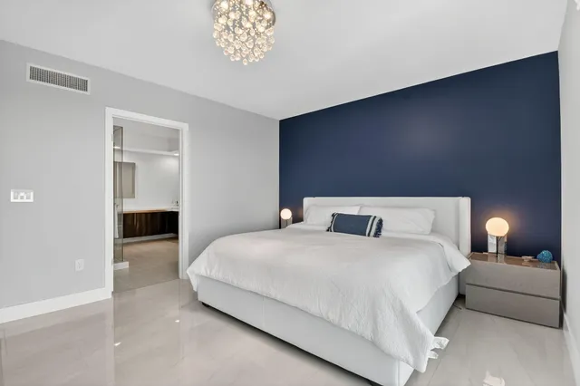 a bedroom with a bed and a chandelier