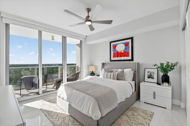 a bedroom with a large bed a chandelier and a window
