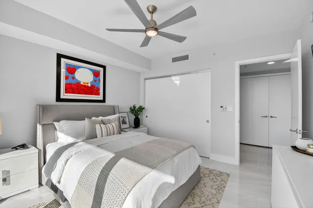 a bedroom with a large bed and a chandelier