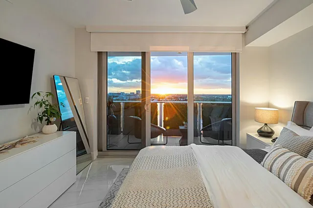 a bedroom with a bed and a flat tv screen on the dresser