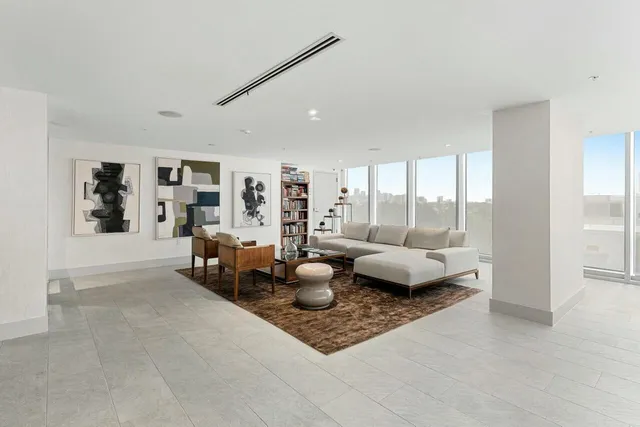 a living room with furniture and floor to ceiling window