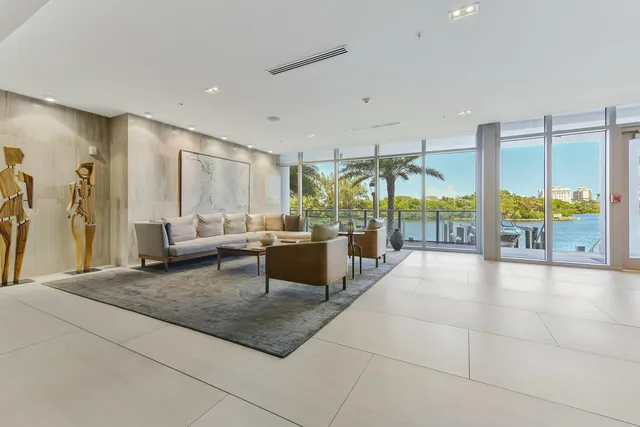 a living room with couches and dining table with chandelier