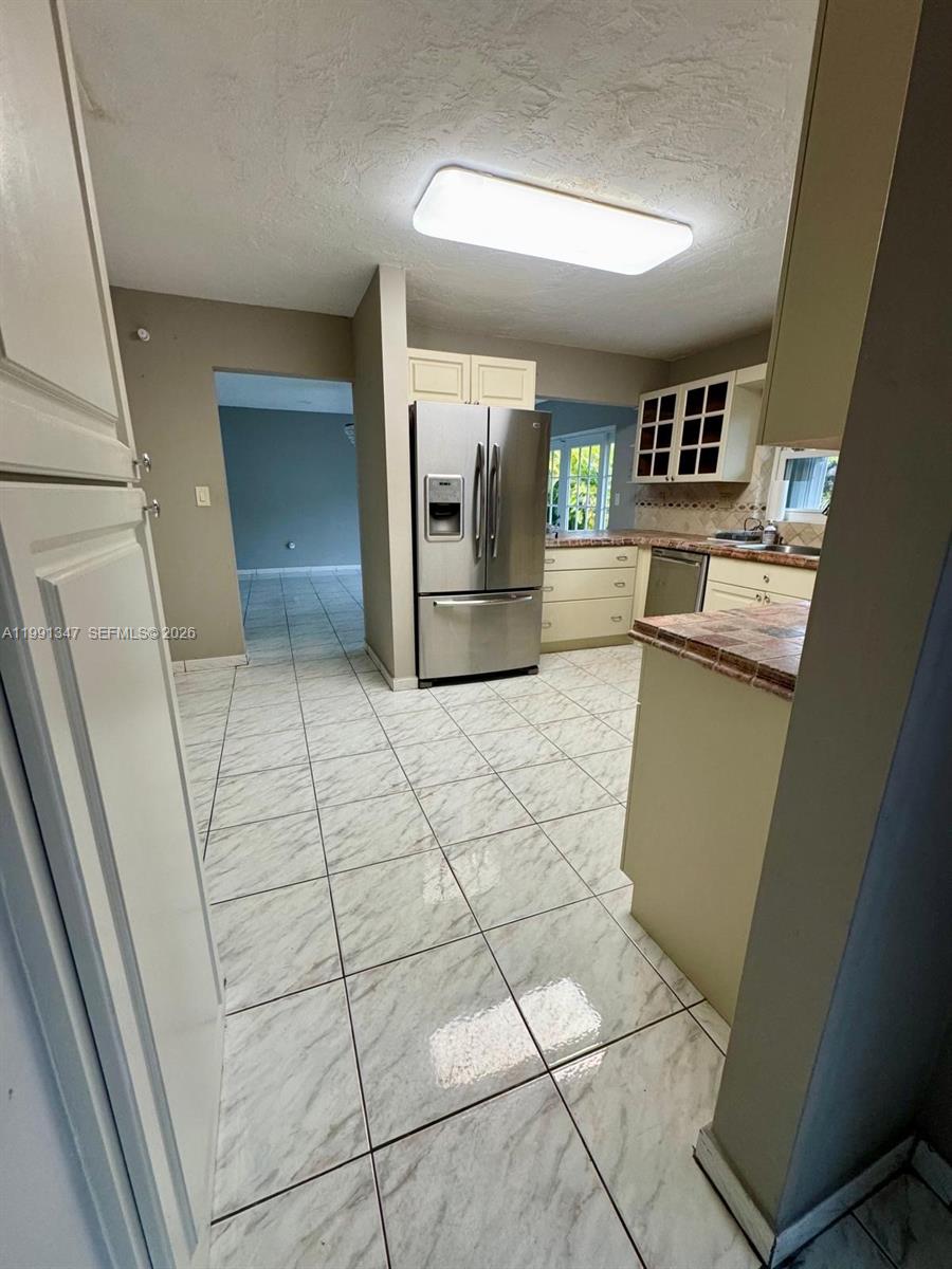 2505 Southwest 126th Avenue Miami, FL 33175 - Photo 7 of 22 a view of a refrigerator and an empty room with wooden floor