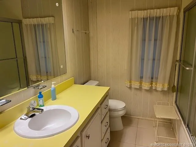 a bedroom with a bed wooden floor and mirror