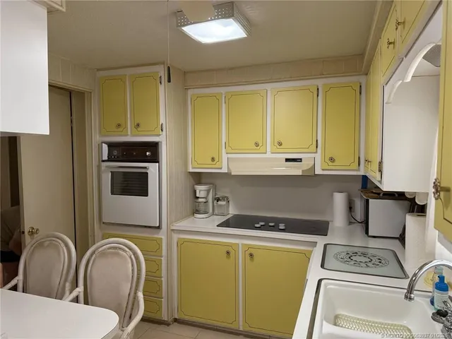 a kitchen with a sink a stove and cabinets