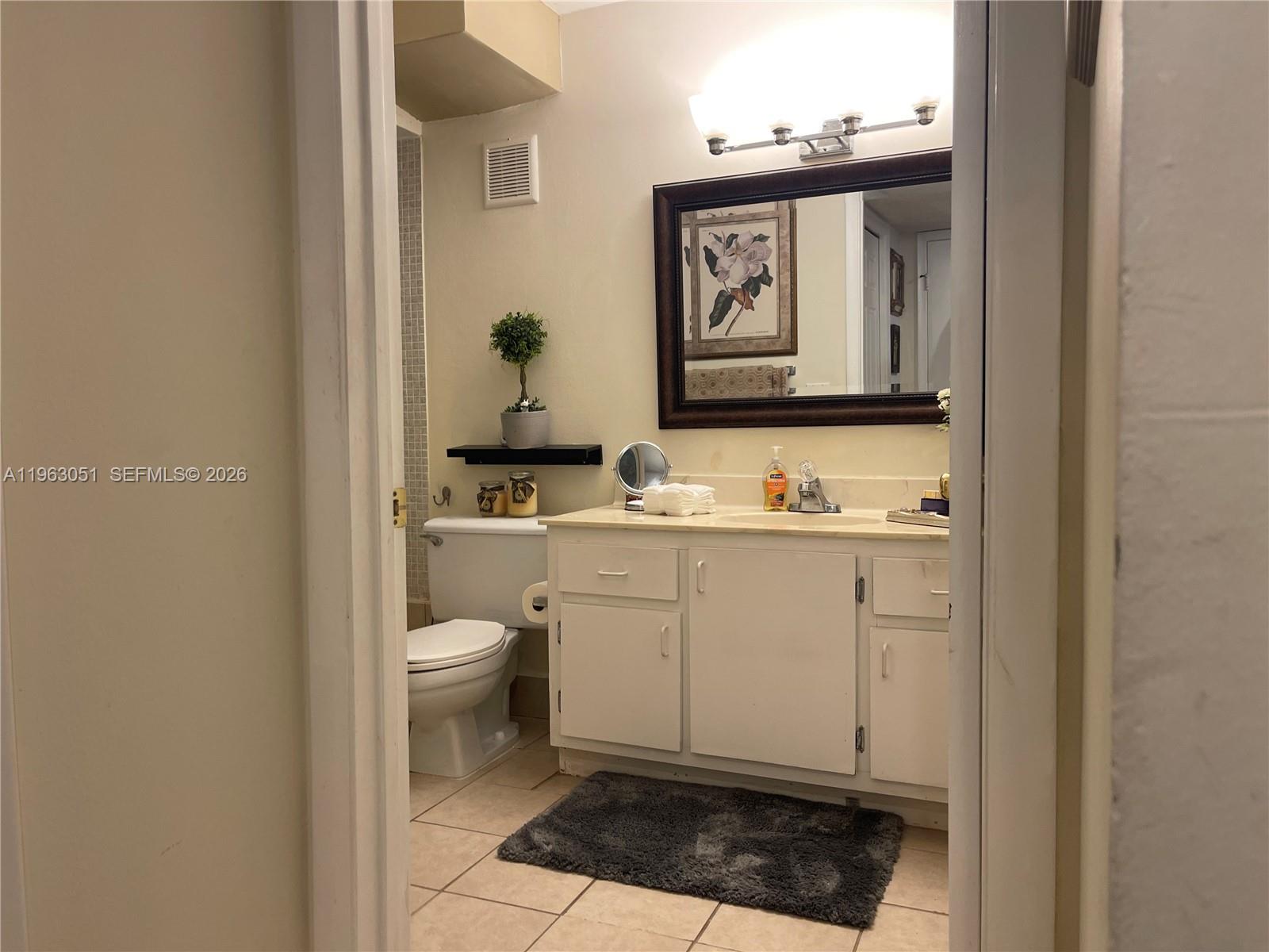 16475 Golf Club Road, Unit 309 Weston, FL 33326 - Photo 18 of 36 a bathroom with a toilet a sink and a mirror