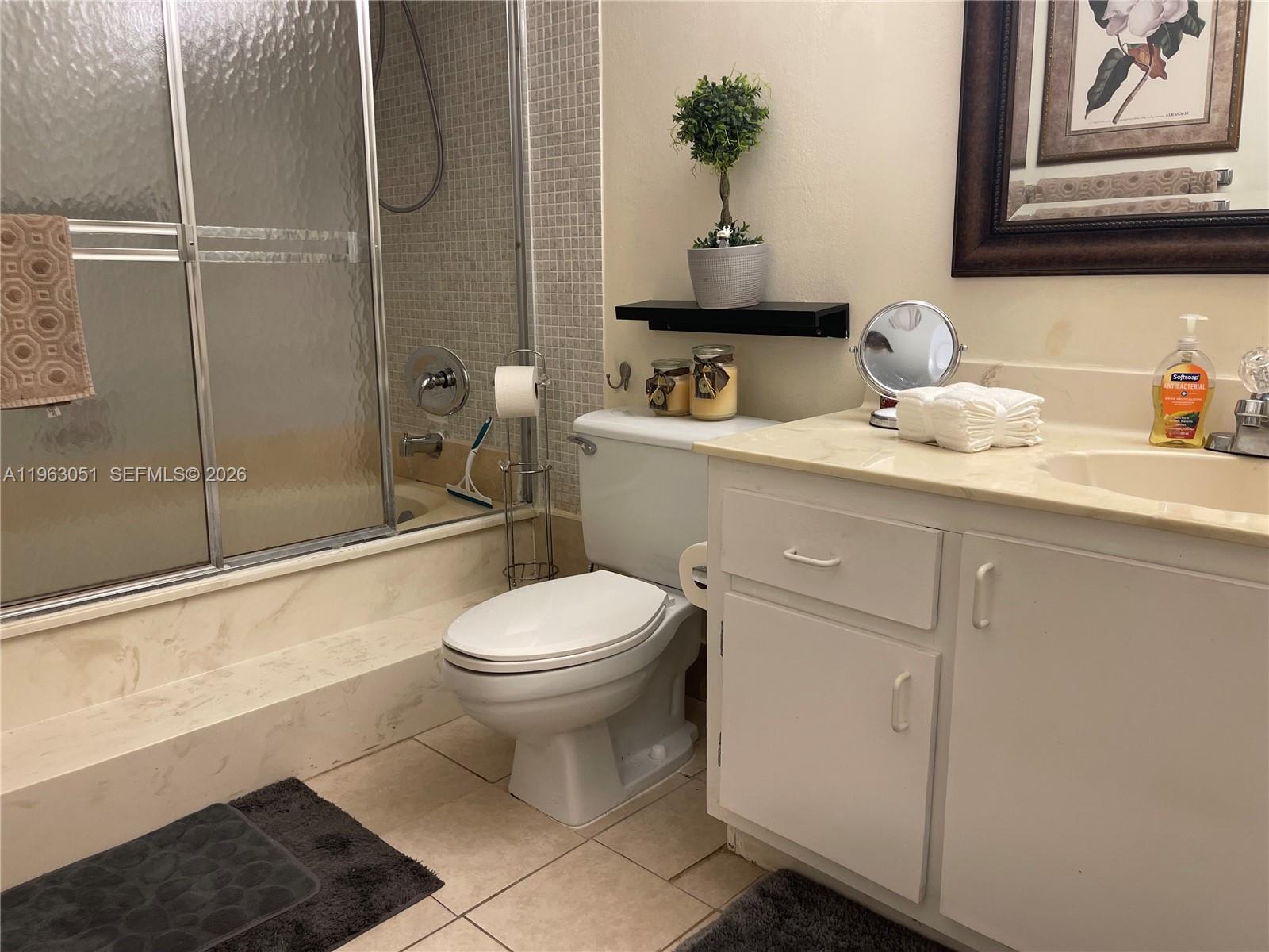 16475 Golf Club Road, Unit 309 Weston, FL 33326 - Photo 19 of 36 a bathroom with a toilet a sink and shower