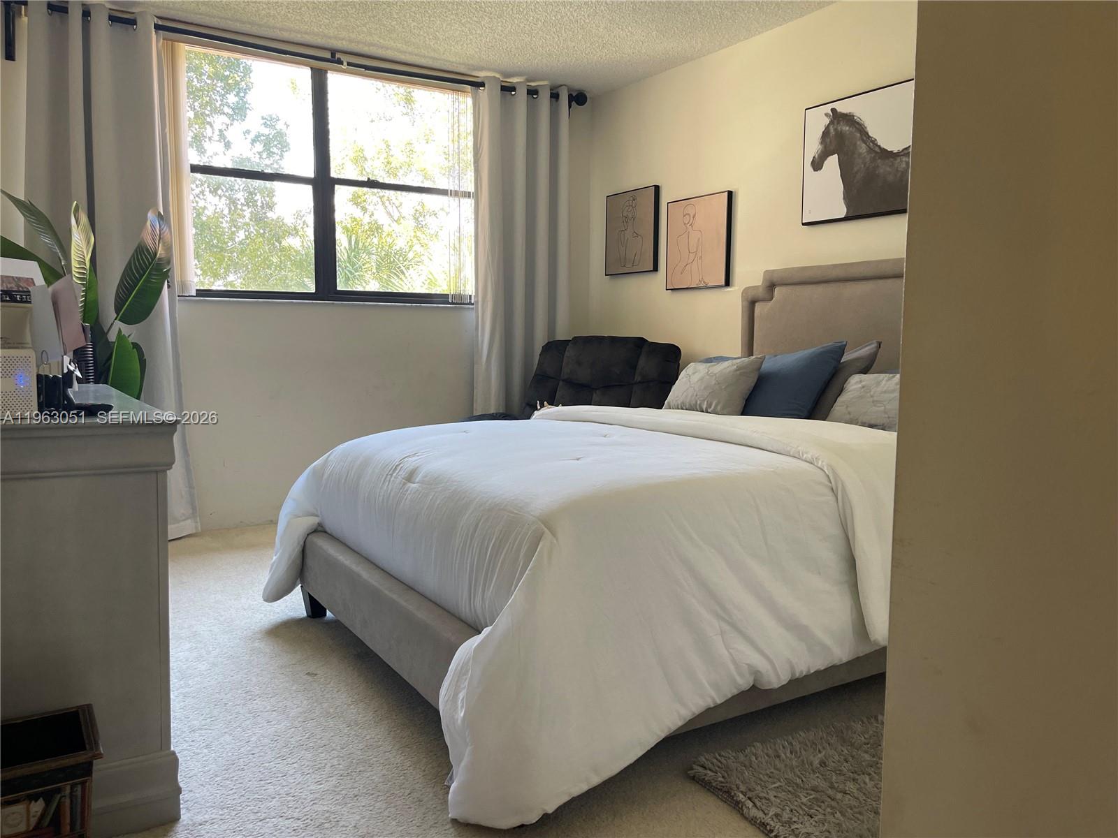 16475 Golf Club Road, Unit 309 Weston, FL 33326 - Photo 20 of 36 a bedroom with a bed and a potted plant on the dresser