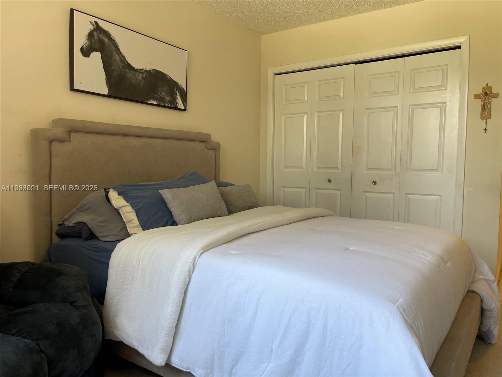 16475 Golf Club Road, Unit 309 Weston, FL 33326 - Photo 21 of 36 a bedroom with a bed and a painting on the wall