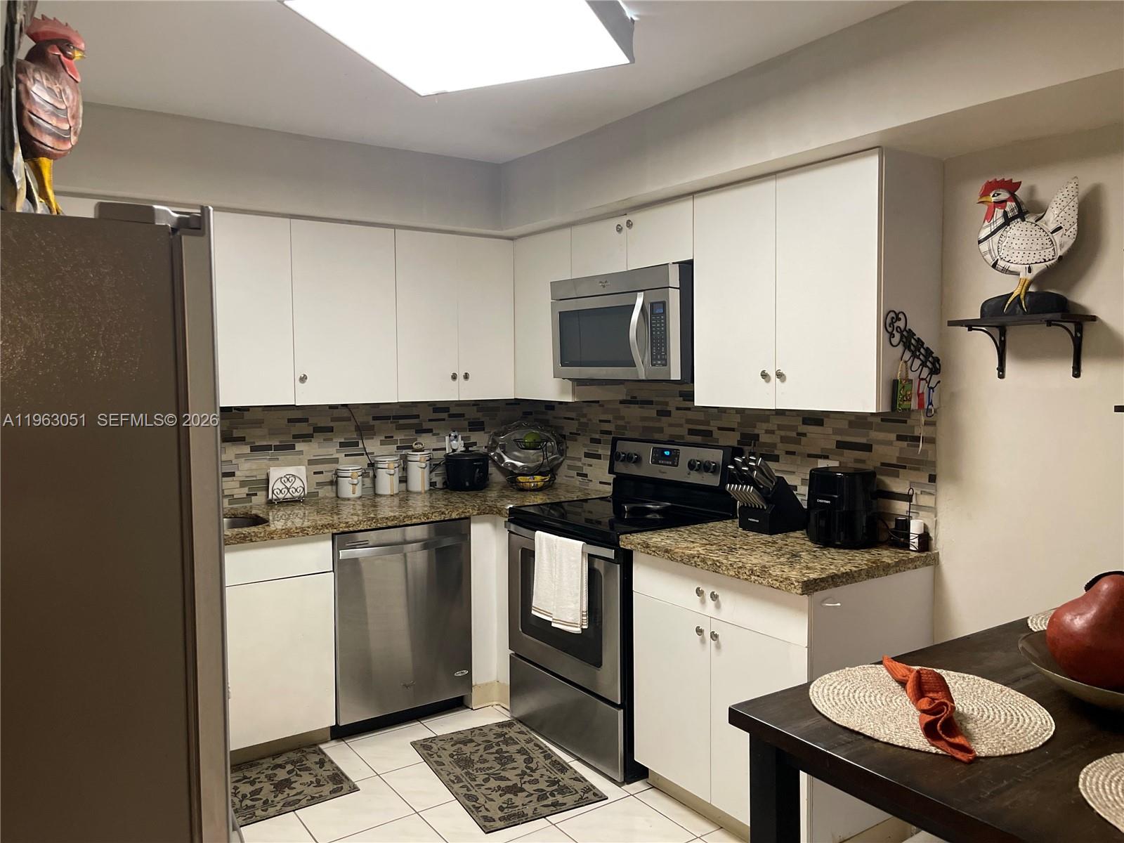 16475 Golf Club Road, Unit 309 Weston, FL 33326 - Photo 5 of 36 a kitchen with a stove and a microwave