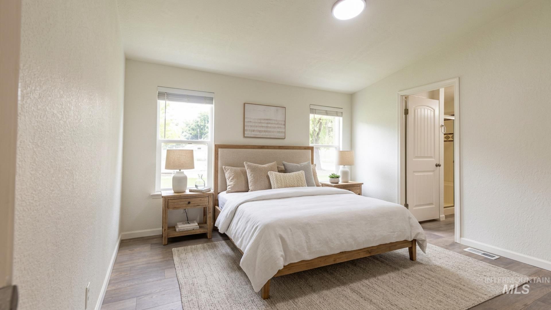 17028 Lower Pleasant Ridge Road Caldwell, ID 83607 - Photo 9 of 21 Bedroom featuring wood-finish flooring, two windows with blinds, and a recessed ceiling light