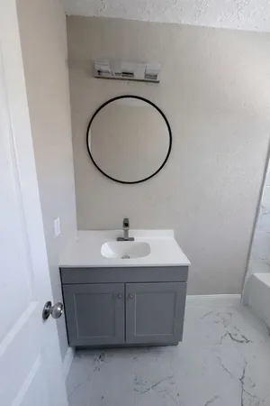 a bathroom with a sink a toilet and a mirror