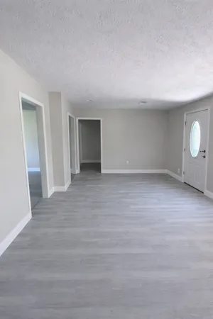 a view of an empty room with wooden floor