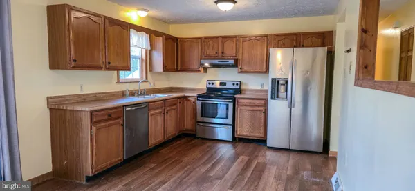 a view of a refrigerator in kitchen and wooden floor
