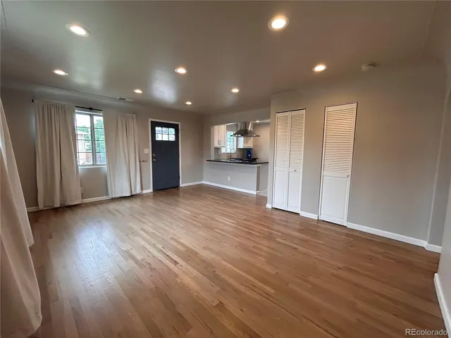 an empty room with wooden floor and a window