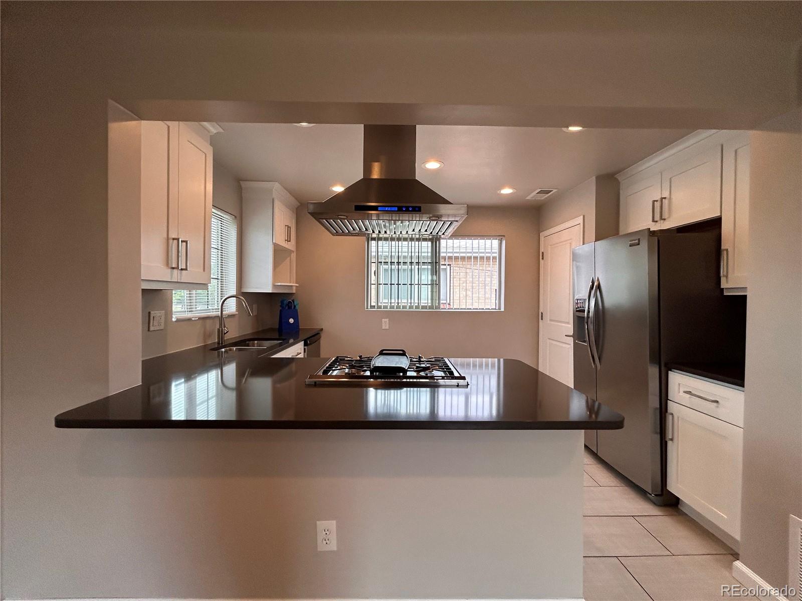 1310 Wolff Street Denver, CO 80204 - Photo 20 of 31 a kitchen with stainless steel appliances granite countertop a refrigerator a stove a sink a microwave and a refrigerator