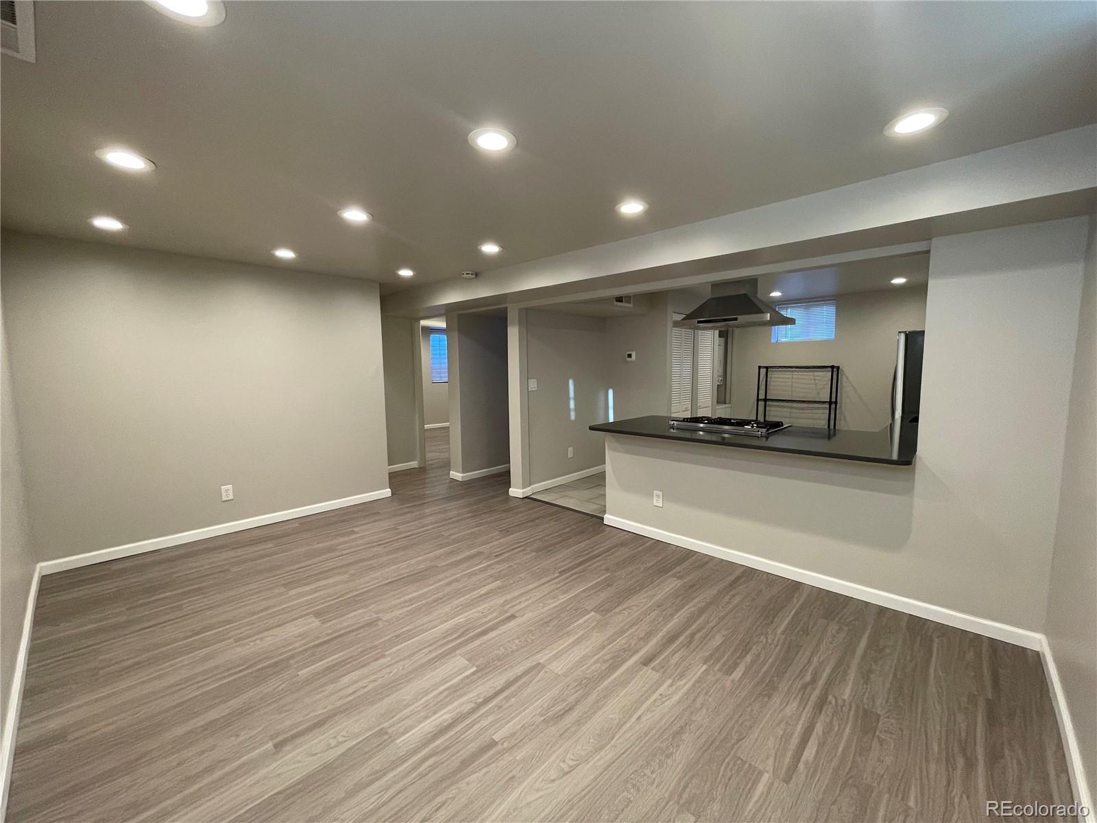 1310 Wolff Street Denver, CO 80204 - Photo 23 of 31 an empty room with wooden floor and kitchen view
