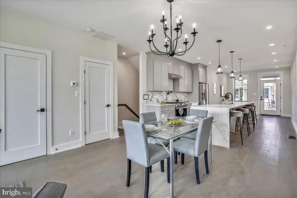 a view of a dining room and livingroom with furniture wooden floor a chandelier